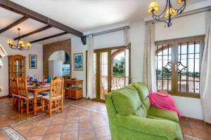 een woonkamer met een groene bank en een tafel bij Villa Tres Olivos by Villa Plus in Frigiliana
