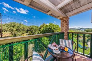 a patio with a table and chairs on a balcony at Villa Rizolia Enea by Villa Plus in Lithakia
