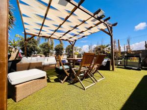 a patio with a table and chairs under a pergola at Caravanas Con Encanto El Palmar in El Palmar