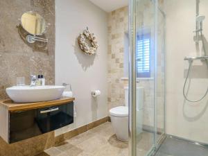 Un baño con lavabo, inodoro y ducha. en 4 Bed in Bamburgh 83373, en Belford 19 fotos más