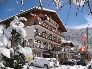 a large building with cars parked in front of it at Hôtel Les Triolets in Châtel +40 photos