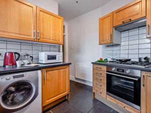 a kitchen with a washing machine and a microwave at 1 Bed in Barton On Sea 91664 in Barton on Sea