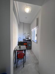 a small kitchen with a table and a red chair at Balcon Six2point in Xanthi