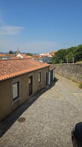 a building with a road next to a wall at Casas Sebastião - Tourist House in Caminha
