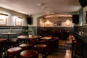 a bar with tables and chairs in a room at Deerpark Inn in Cavan