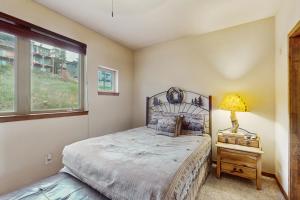 a bedroom with a bed and a lamp and a window at View House in Fraser
