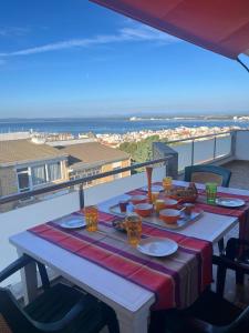 a table on a balcony with a view of the ocean at Costa Brava - Roses - Terrace & sea view in Roses +12 photos