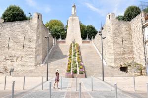 a woman is standing in front of a monument at Les Planches in Verdun-sur-Meuse