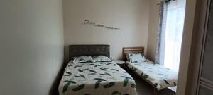 une chambre avec deux lits et une fenêtre dans l'établissement Minimalist Homestay Dungun, à Kampong Sura Tengah
