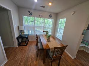 a dining room with a table and chairs and windows at The Lake House in Gautier