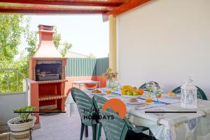 d'une terrasse avec une table et une cheminée. dans l'établissement #240 Beach House - Casa da Balaia by Home Holidays, à Olhos de Água