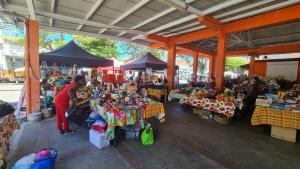 an outdoor market with a person standing in front of tables at Habitation Noëlesse - vue mer à Marie-Galante - authentique et romantique in Beauregard