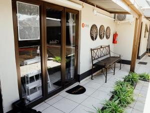 a patio with a bench on the side of a building at Ehrlichpark Lodge self catering and spa in Bloemfontein