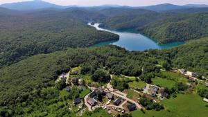 普利特維采村的住宿－Ethno Houses Plitvice Lakes Hotel，享有房子和湖泊的空中景致