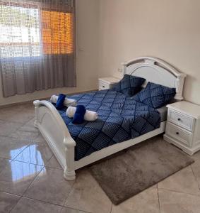 a bedroom with a bed with a blue comforter at City Center Blue Pearl in Al Hoceïma