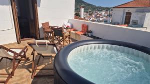 a hot tub on a balcony with chairs and a table at Adele house in Skopelos Town