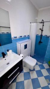 a blue and white bathroom with a toilet and a sink at City Center Blue Pearl in Al Hoceïma