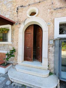 ein Eingang zu einem Gebäude mit einer Holztür in der Unterkunft La Casa In Piazza in Marina di Camerota