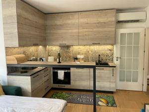 a kitchen with wooden cabinets and a counter top at Complex Gallery Saint Thomas in Sozopol