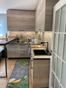 a kitchen with wooden cabinets and a sink at Complex Gallery Saint Thomas in Sozopol