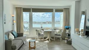 a living room with a couch and a table with chairs at Penthouse MEERblick, App 66 in Westerland (Sylt)