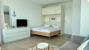 a bedroom with a bed and a tv in it at Penthouse MEERblick, App 66 in Westerland (Sylt)