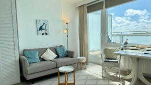 a living room with a couch and a large window at Penthouse MEERblick, App 66 in Westerland (Sylt)
