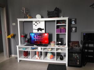 a white book shelf with a tv on it at Affittacamere Erbagatta in Erba
