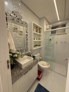 a bathroom with a toilet and a sink and a shower at Apartamento Residencial Serigy in Aracaju