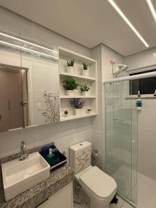 a bathroom with a toilet and a sink and a shower at Apartamento Residencial Serigy in Aracaju +4 photos