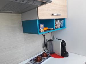 a kitchen with a blue cabinet above a microwave at Affittacamere Erbagatta in Erba