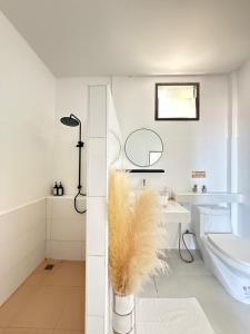 a white bathroom with a toilet and a sink at Beachfront house in Chaloklum in Mae Haad +24 photos