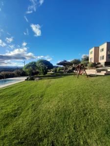 a grassy field with a playground in a park at Ayres Serranos in Villa Carlos Paz
