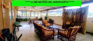 a living room with chairs and a table and windows at El Jardín cerca Aeropuerto de Pasto, comodidad y descanso in Chachagüí