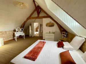 a bedroom with a white bed in a attic at Le Château de Leugny in Oiron +90 photos