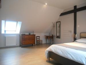 a bedroom with a bed and a dresser and a window at Maison Chauvin in Château-du-Loir