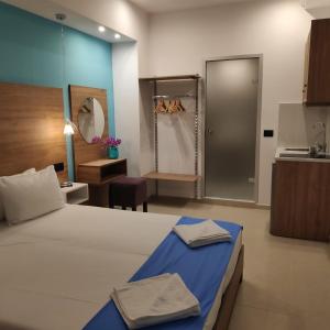 a bedroom with a bed and a bathroom with a sink at Anemone Suites in Georgioupolis