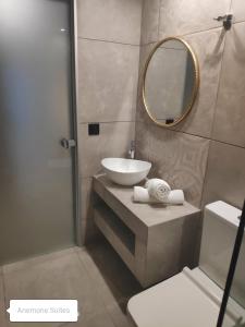 a bathroom with a sink and a mirror at Anemone Suites in Georgioupolis
