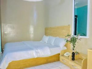 a bedroom with a bed with a phone and a table at Abuja Bays Garden Hotel Ltd in Mama
