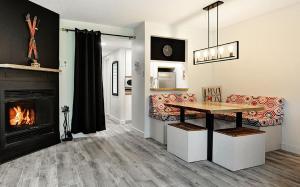 a living room with a table and a fireplace at Hameau 28-51 Studio in Stoneham
