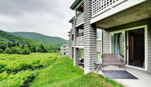 a house with a chair on a porch with a field at Hameau 28-51 Studio in Stoneham