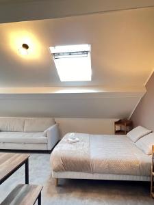 a bedroom with a bed and a couch and a window at Studio B6 - Centre-Ville Meaux - Proche Disneyland in Meaux