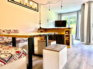 a living room with a table and a desk at Hameau 28-51 Studio in Stoneham