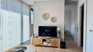 un soggiorno con TV e tavolo in legno di CityLounge a Westerland