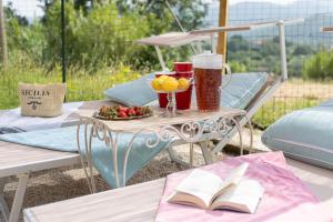 a table with a book and a plate of fruit at Villa Isabò by VacaVilla in Capannori