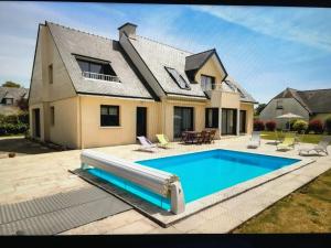 a house with a swimming pool in front of a house at Villa spacieuse à Concarneau avec piscine privée in Concarneau