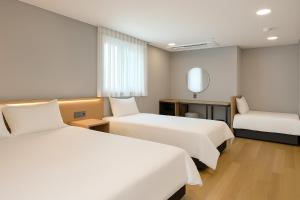 a hotel room with two beds and a mirror at Seoul DDJ STAY 대동장 in Seoul