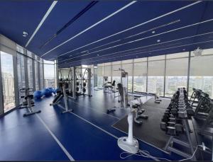 a gym with blue walls and a large window at City Lights Retreat in Ban Na Song