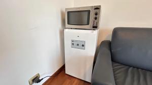 a tv sitting on top of a refrigerator next to a chair at Skyline Verona in Verona
