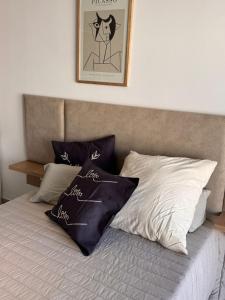 a bed with black and white pillows on it at Suit Chalet Santiago in Santiago del Estero +15 photos
